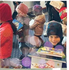 Children at a Ukrainian orphanage receiving Christmas gift boxes and books.