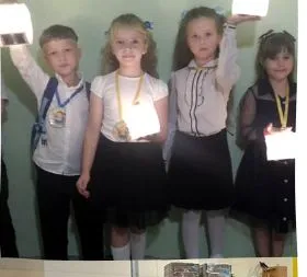 Four children holding lights at an orphanage in Eastern Europe.