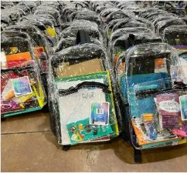 Clear backpacks filled with school supplies for homeless and underserved children.